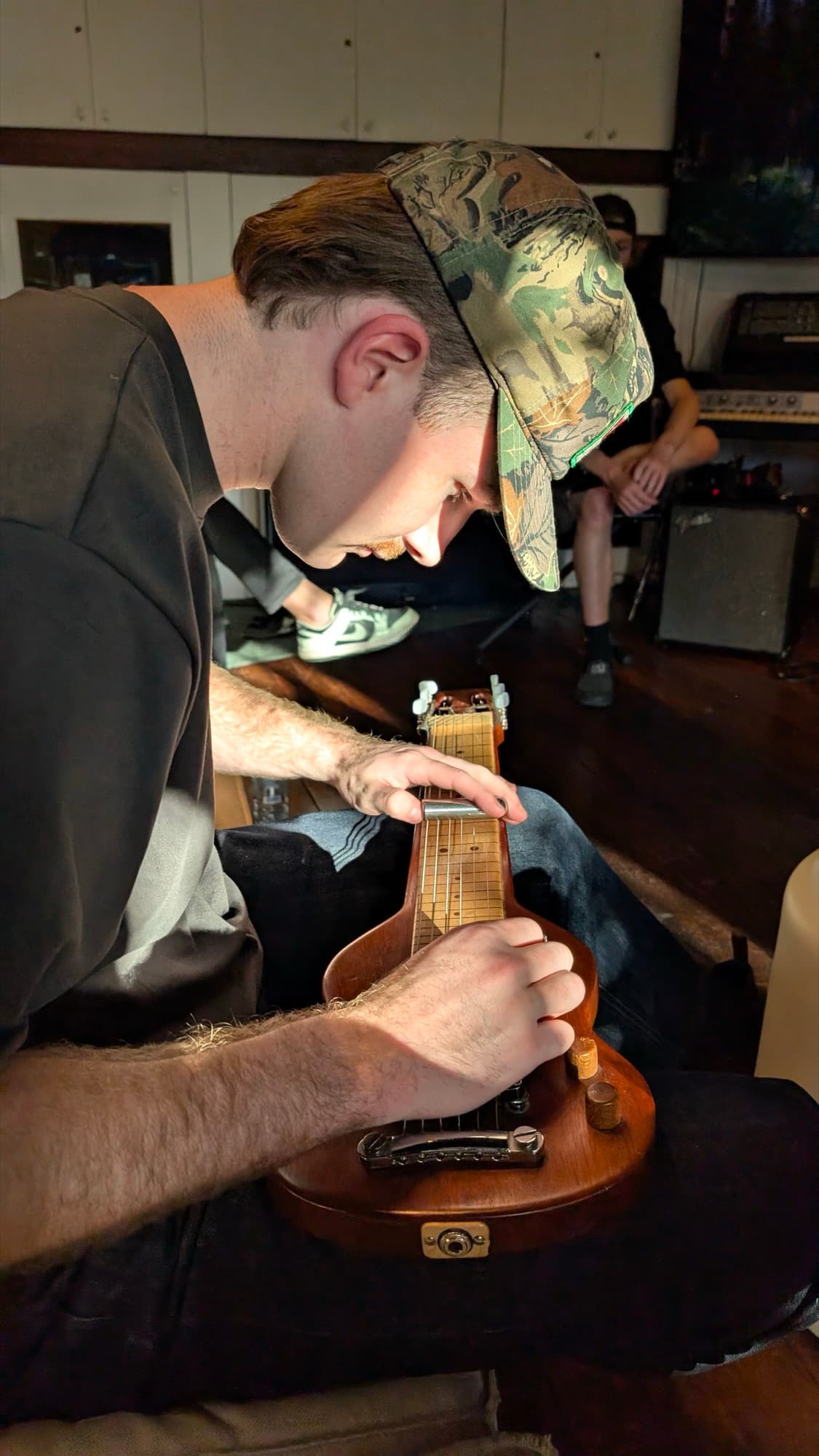 Kai Rennie playing guitar in the studio